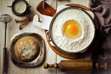 Mutfak aksesuarları ile bir kompozisyon içinde eski bir arka plan üzerinde un ile hamur