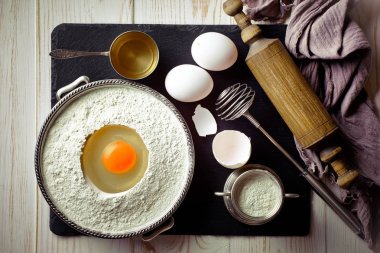 Mutfak aksesuarları ile bir kompozisyon içinde eski bir arka plan üzerinde un ile hamur