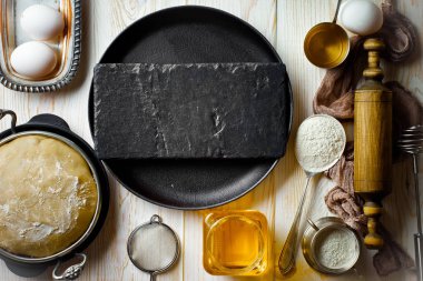 Mutfak aksesuarları ile bir kompozisyon içinde eski bir arka plan üzerinde un ile hamur