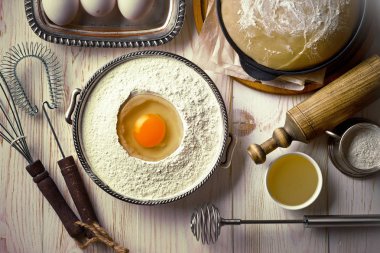 Mutfak aksesuarları ile bir kompozisyon içinde eski bir arka plan üzerinde un ile hamur