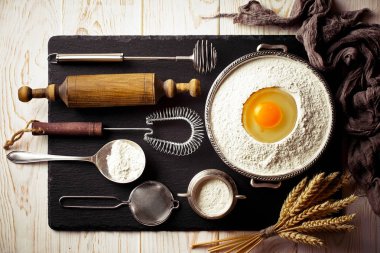 Mutfak aksesuarları ile bir kompozisyon içinde eski bir arka plan üzerinde un ile hamur