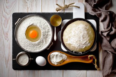 Mutfak aksesuarları ile bir kompozisyon içinde eski bir arka plan üzerinde un ile hamur