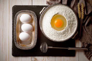 Mutfak aksesuarları ile bir kompozisyon içinde eski bir arka plan üzerinde un ile hamur