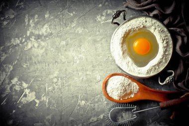 Mutfak aksesuarları ile bir kompozisyon içinde eski bir arka plan üzerinde un ile hamur