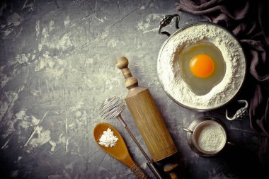 Mutfak aksesuarları ile bir kompozisyon içinde eski bir arka plan üzerinde un ile hamur