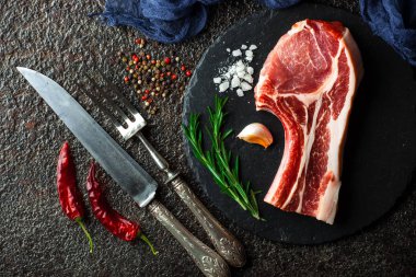 Mutfak masasında aksesuarları pişirme ile bir kompozisyon içinde metalik bir arka plan üzerinde çiğ et