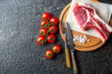 Mutfak masasında aksesuarları pişirme ile bir kompozisyon içinde metalik bir arka plan üzerinde çiğ et