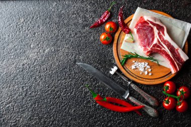 Mutfak masasında aksesuarları pişirme ile bir kompozisyon içinde metalik bir arka plan üzerinde çiğ et