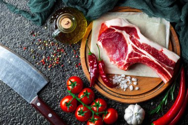 Mutfak masasında aksesuarları pişirme ile bir kompozisyon içinde metalik bir arka plan üzerinde çiğ et