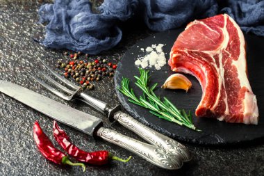 Mutfak masasında aksesuarları pişirme ile bir kompozisyon içinde metalik bir arka plan üzerinde çiğ et