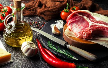 Mutfak masasında aksesuarları pişirme ile bir kompozisyon içinde metalik bir arka plan üzerinde çiğ et