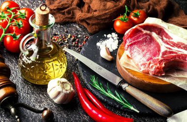 Mutfak masasında aksesuarları pişirme ile bir kompozisyon içinde metalik bir arka plan üzerinde çiğ et