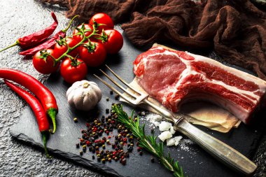 Mutfak masasında aksesuarları pişirme ile bir kompozisyon içinde metalik bir arka plan üzerinde çiğ et