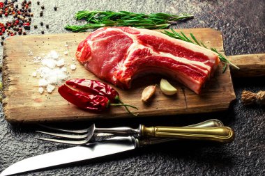 Mutfak masasında aksesuarları pişirme ile bir kompozisyon içinde metalik bir arka plan üzerinde çiğ et