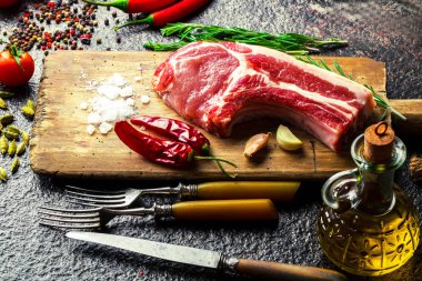 Mutfak masasında aksesuarları pişirme ile bir kompozisyon içinde metalik bir arka plan üzerinde çiğ et