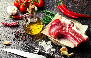 Mutfak masasında aksesuarları pişirme ile bir kompozisyon içinde metalik bir arka plan üzerinde çiğ et