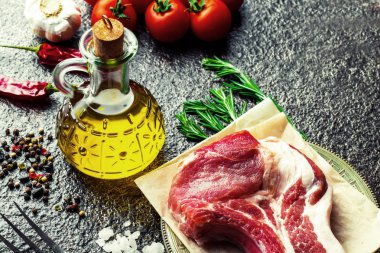 Mutfak masasında aksesuarları pişirme ile bir kompozisyon içinde metalik bir arka plan üzerinde çiğ et