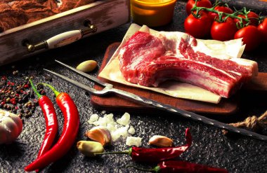 Mutfak masasında aksesuarları pişirme ile bir kompozisyon içinde metalik bir arka plan üzerinde çiğ et