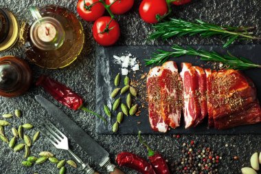 Mutfak masasında aksesuarları pişirme ile bir kompozisyon içinde metalik bir arka plan üzerinde çiğ et