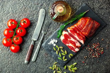 Mutfak masasında aksesuarları pişirme ile bir kompozisyon içinde metalik bir arka plan üzerinde çiğ et