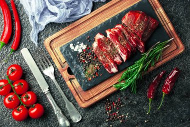 Mutfak masasında aksesuarları pişirme ile bir kompozisyon içinde metalik bir arka plan üzerinde çiğ et