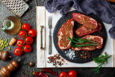 Mutfak masasında aksesuarları pişirme ile bir kompozisyon içinde metalik bir arka plan üzerinde çiğ et