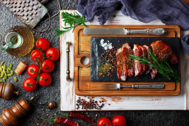 Mutfak masasında aksesuarları pişirme ile bir kompozisyon içinde metalik bir arka plan üzerinde çiğ et