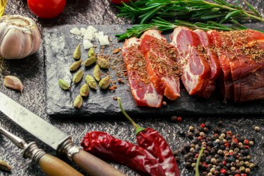 Mutfak masasında aksesuarları pişirme ile bir kompozisyon içinde metalik bir arka plan üzerinde çiğ et