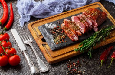 Mutfak masasında aksesuarları pişirme ile bir kompozisyon içinde metalik bir arka plan üzerinde çiğ et