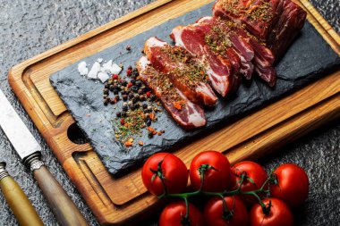 Mutfak masasında aksesuarları pişirme ile bir kompozisyon içinde metalik bir arka plan üzerinde çiğ et