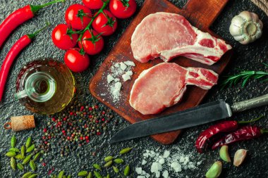 Mutfak masasında aksesuarları pişirme ile bir kompozisyon içinde metalik bir arka plan üzerinde çiğ et