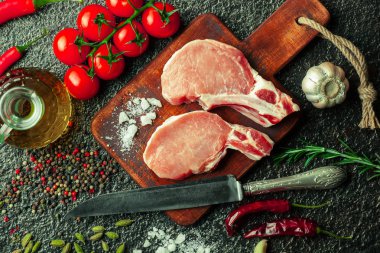 Mutfak masasında aksesuarları pişirme ile bir kompozisyon içinde metalik bir arka plan üzerinde çiğ et