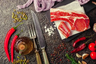 Mutfak masasında aksesuarları pişirme ile bir kompozisyon içinde metalik bir arka plan üzerinde çiğ et