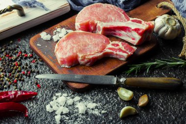 Mutfak masasında aksesuarları pişirme ile bir kompozisyon içinde metalik bir arka plan üzerinde çiğ et