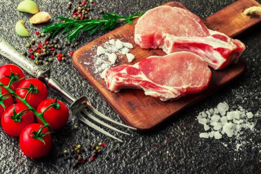 Mutfak masasında aksesuarları pişirme ile bir kompozisyon içinde metalik bir arka plan üzerinde çiğ et