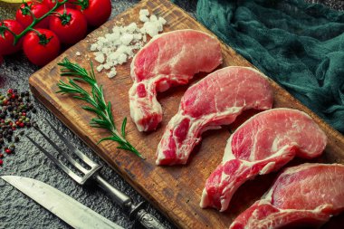 Mutfak masasında aksesuarları pişirme ile bir kompozisyon içinde metalik bir arka plan üzerinde çiğ et