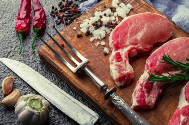 Mutfak masasında aksesuarları pişirme ile bir kompozisyon içinde metalik bir arka plan üzerinde çiğ et