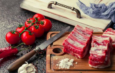 Mutfak masasında aksesuarları pişirme ile bir kompozisyon içinde metalik bir arka plan üzerinde çiğ et