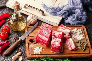 Mutfak masasında aksesuarları pişirme ile bir kompozisyon içinde metalik bir arka plan üzerinde çiğ et