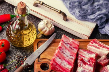 Mutfak masasında aksesuarları pişirme ile bir kompozisyon içinde metalik bir arka plan üzerinde çiğ et