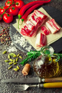 Mutfak masasında aksesuarları pişirme ile bir kompozisyon içinde metalik bir arka plan üzerinde çiğ et