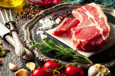 Mutfak masasında aksesuarları pişirme ile bir kompozisyon içinde metalik bir arka plan üzerinde çiğ et