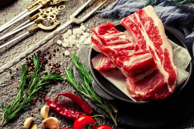 Mutfak masasında aksesuarları pişirme ile bir kompozisyon içinde metalik bir arka plan üzerinde çiğ et