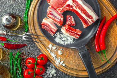 Mutfak masasında aksesuarları pişirme ile bir kompozisyon içinde metalik bir arka plan üzerinde çiğ et