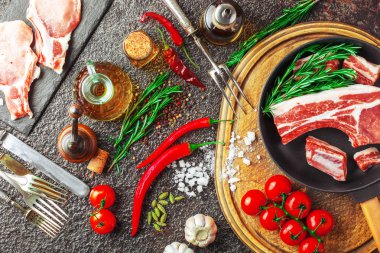 Mutfak masasında aksesuarları pişirme ile bir kompozisyon içinde metalik bir arka plan üzerinde çiğ et