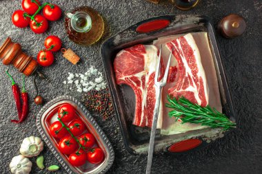 Mutfak masasında aksesuarları pişirme ile bir kompozisyon içinde metalik bir arka plan üzerinde çiğ et