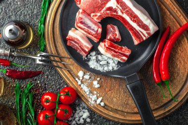 Mutfak masasında aksesuarları pişirme ile bir kompozisyon içinde metalik bir arka plan üzerinde çiğ et