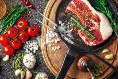 Mutfak masasında aksesuarları pişirme ile bir kompozisyon içinde metalik bir arka plan üzerinde çiğ et