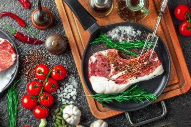 Mutfak masasında aksesuarları pişirme ile bir kompozisyon içinde metalik bir arka plan üzerinde çiğ et