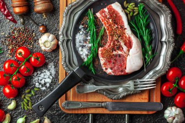 Mutfak masasında aksesuarları pişirme ile bir kompozisyon içinde metalik bir arka plan üzerinde çiğ et